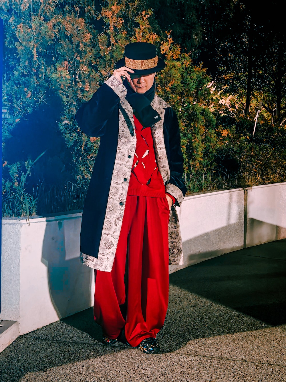 レッド系のニット/セーター、レッド系のその他パンツ、ベージュ系のTシャツ/カットソーを着用したメンズの秋コーディネートの2枚目の写真