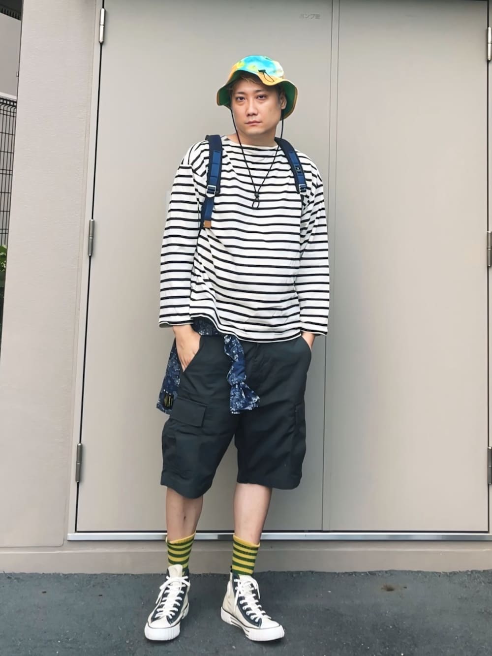 ホワイト系のTシャツ/カットソー、ブルー系のバックパック/リュック、ブラック系のカーゴパンツを着用したメンズの夏コーディネートの2枚目の写真