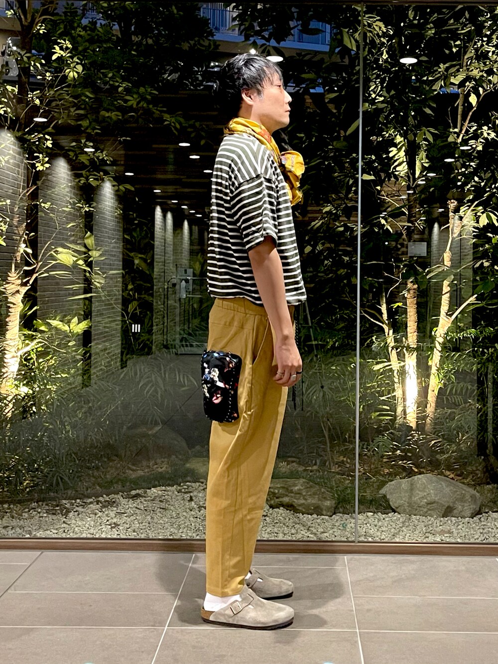 グリーン系のTシャツ/カットソー、ベージュ系のチノパンツ、ベージュ系のサンダルを着用したメンズの夏コーディネートの2枚目の写真