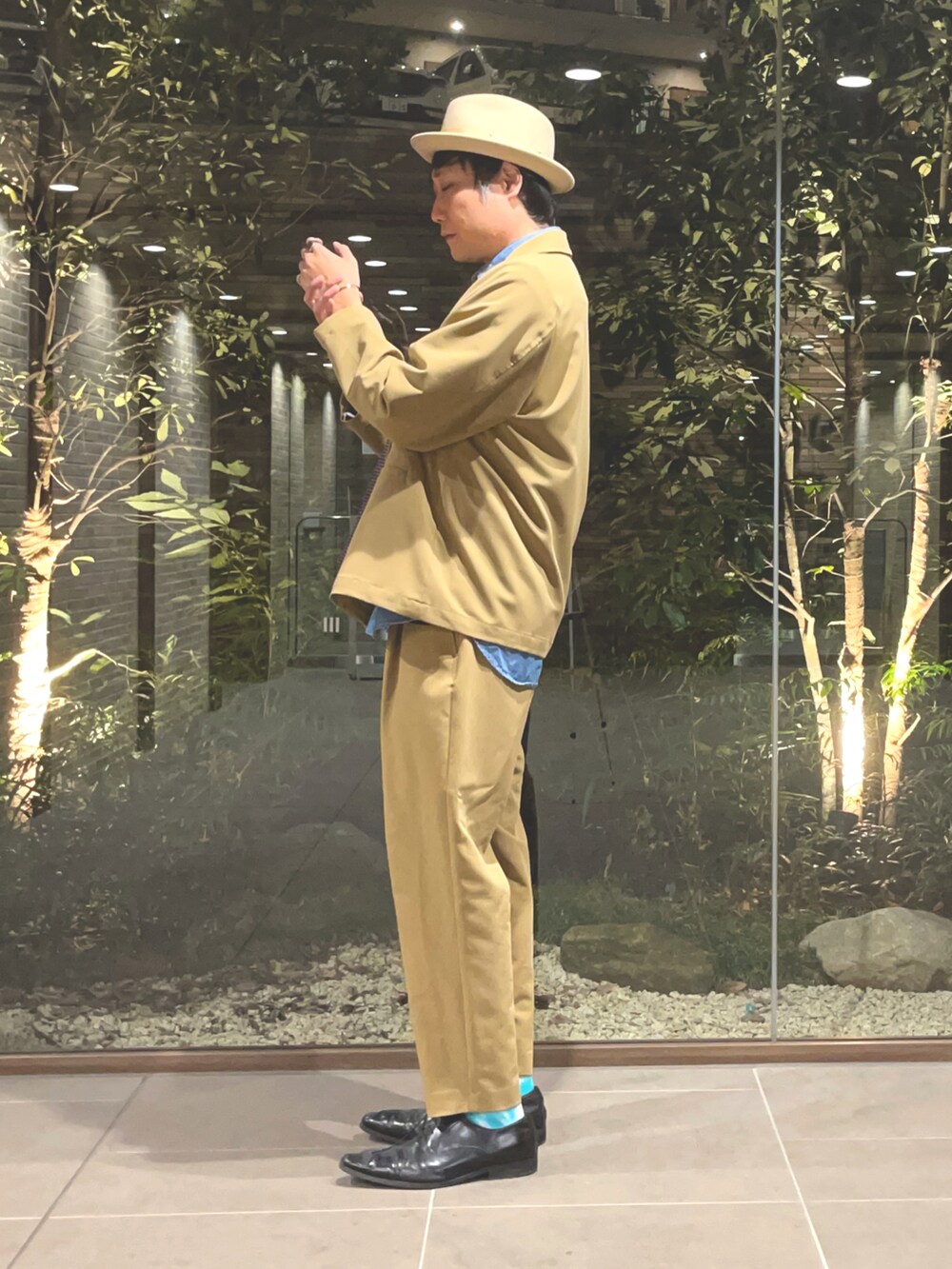 パープル系のネクタイ、ブルー系のシャツ/ブラウス、ベージュ系のスラックスを着用したメンズの冬コーディネートの2枚目の写真