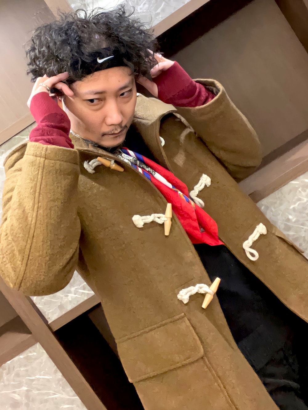 グリーン系のダッフルコート、ブラック系のニット/セーター、ブラック系のパンツを着用したメンズの冬コーディネートの3枚目の写真