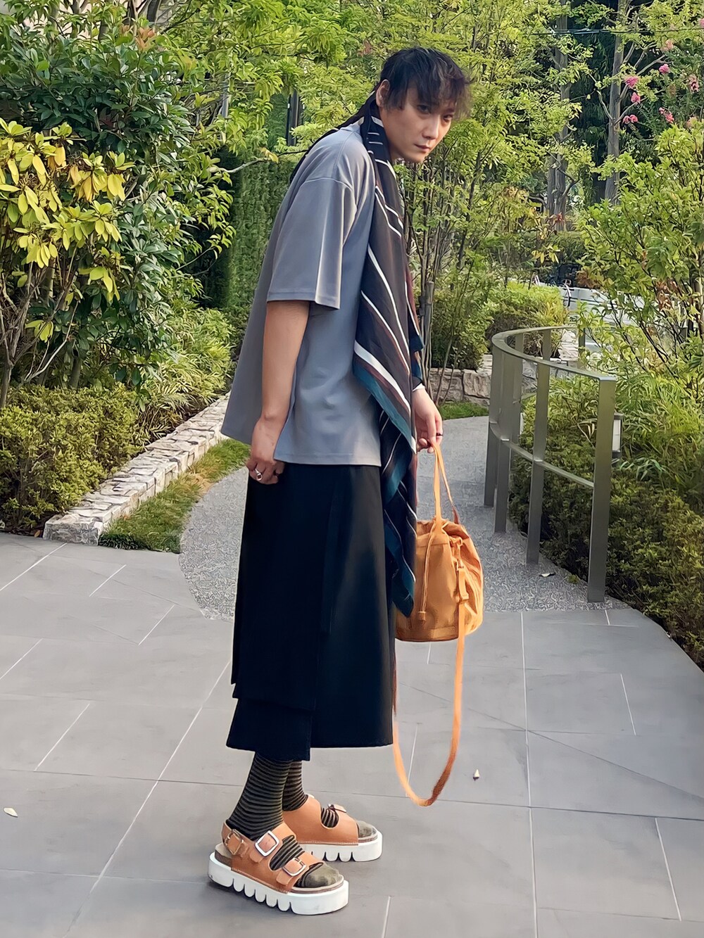 イエロー系のバッグ、ブラック系のパンツ、ベージュ系のその他シューズを着用したメンズの夏コーディネートの3枚目の写真