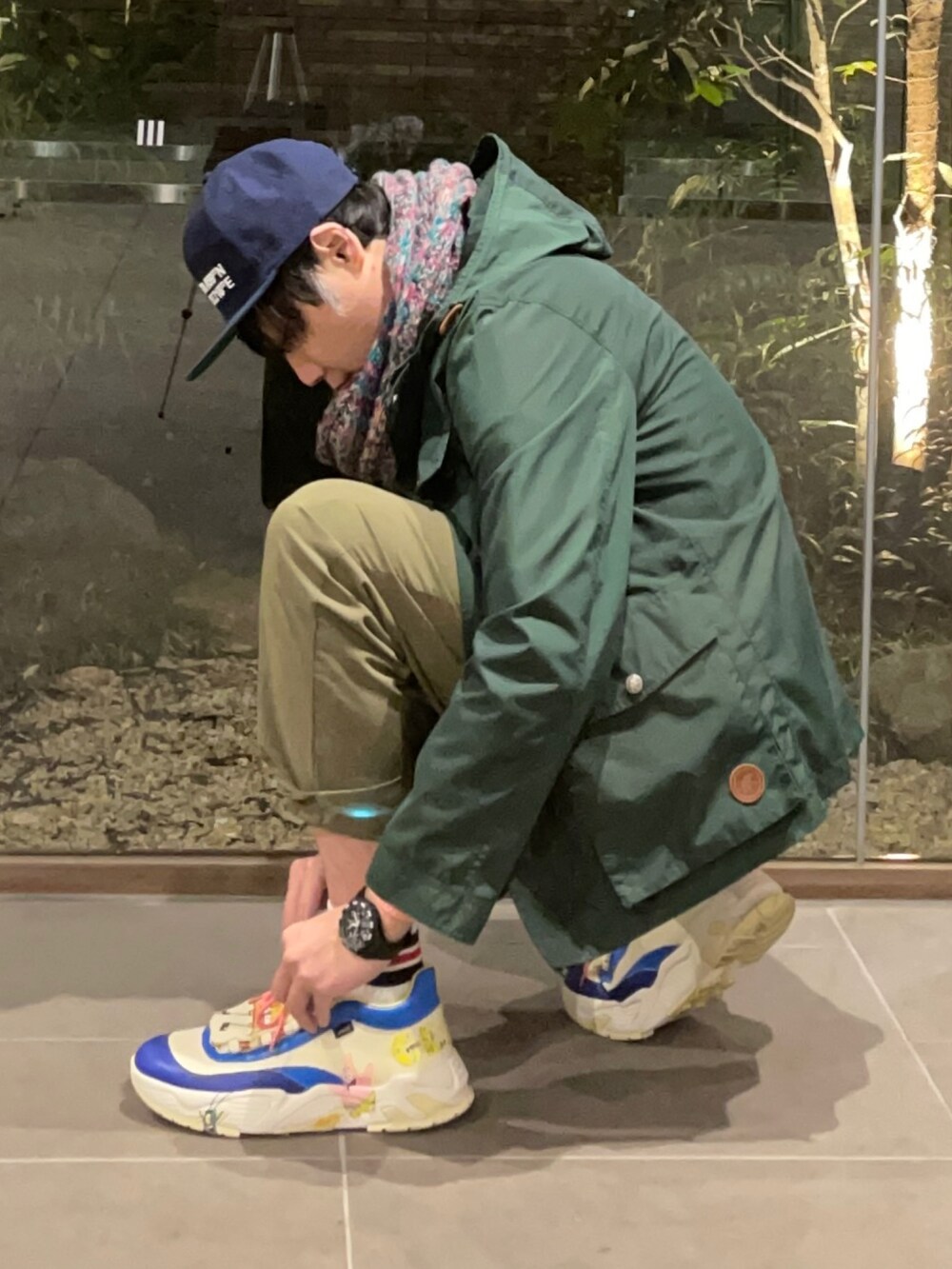 ピンク系のニット/セーター、グリーン系のマウンテンパーカー、グリーン系のその他パンツを着用したメンズの春コーディネートの3枚目の写真