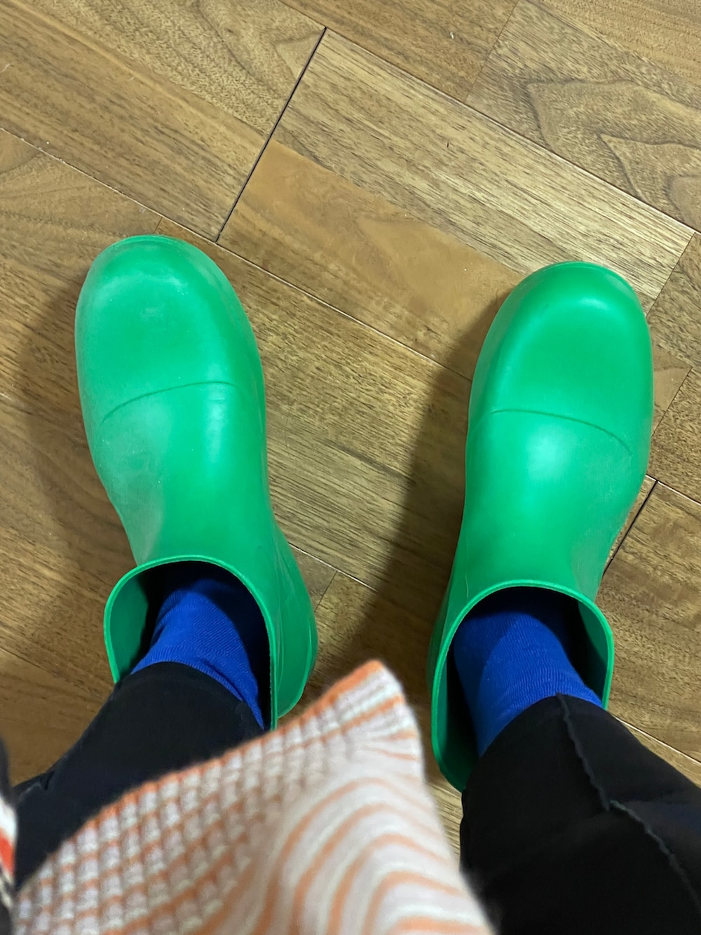 ブラック系のその他アウター、ブラック系のその他パンツ、グリーン系のレインシューズを着用したメンズの春コーディネートの3枚目の写真