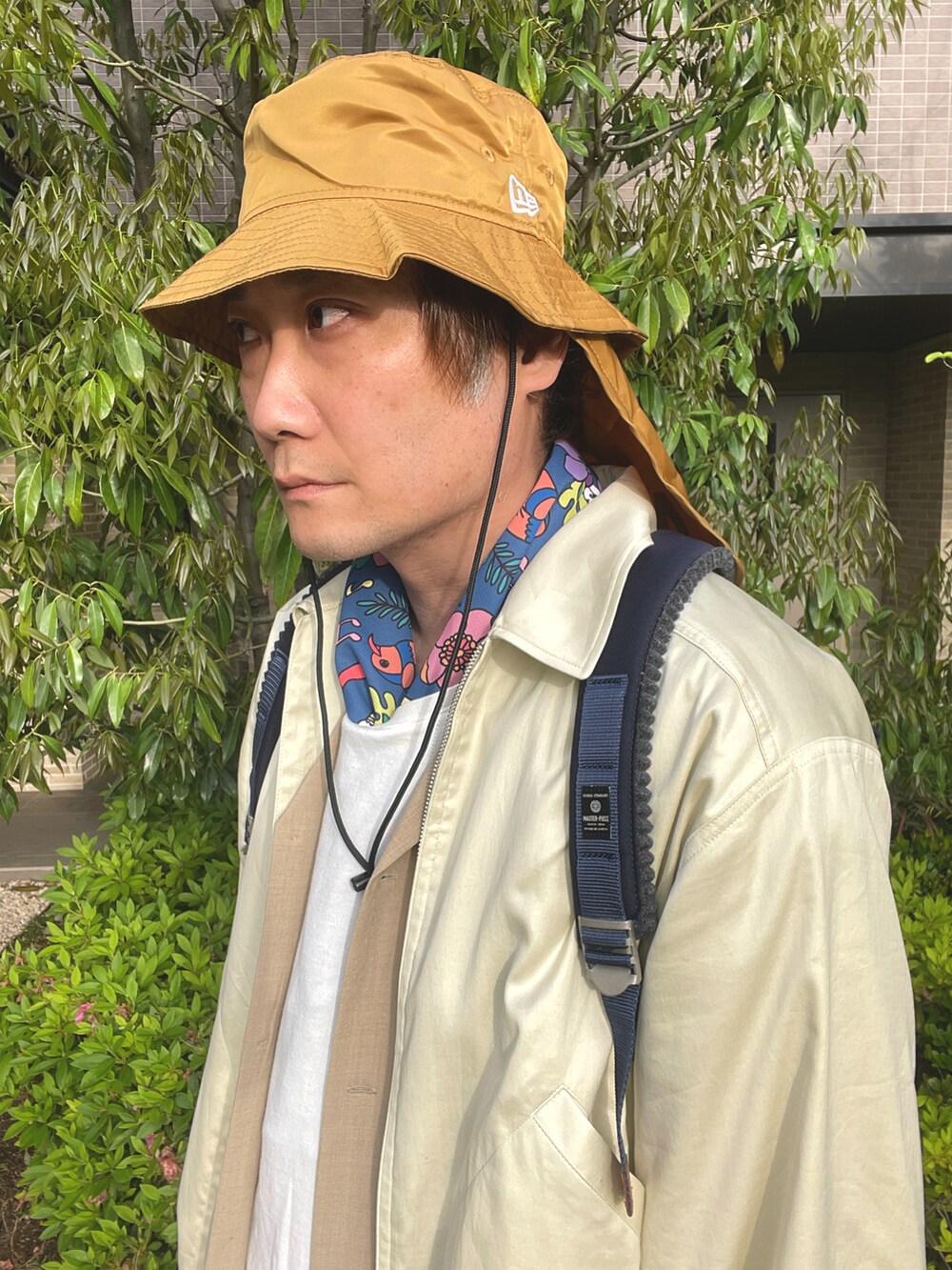 ブルー系のバックパック/リュック、ベージュ系のブルゾン、ベージュ系のシャツ/ブラウスを着用したメンズの春コーディネートの3枚目の写真