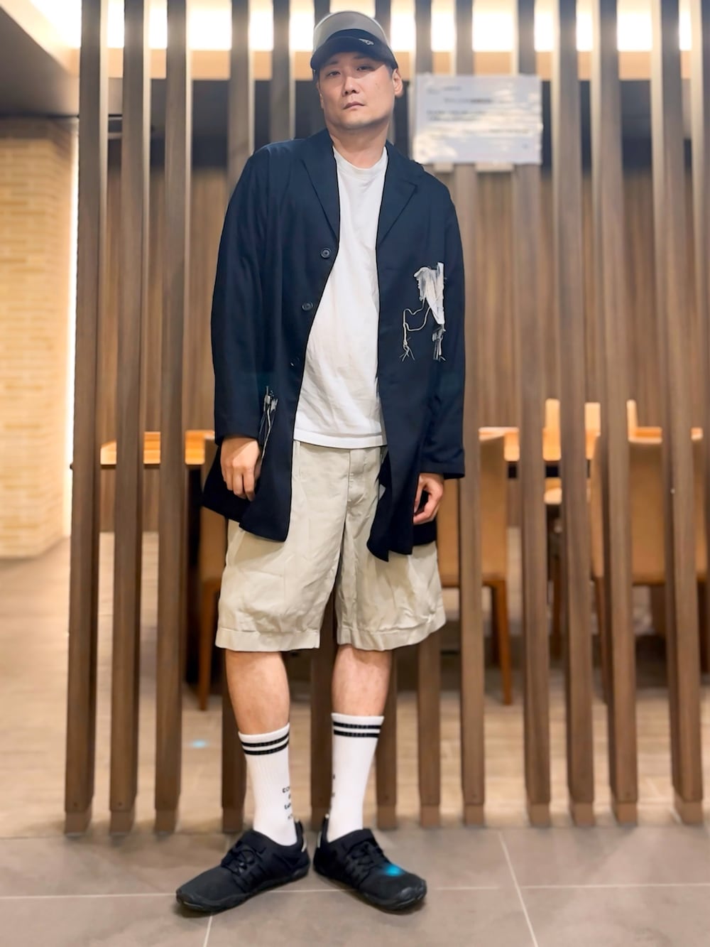 ホワイト系のTシャツ/カットソー、ブラック系のジャケット/アウター、ベージュ系のチノパンツを着用したメンズの秋コーディネートの2枚目の写真