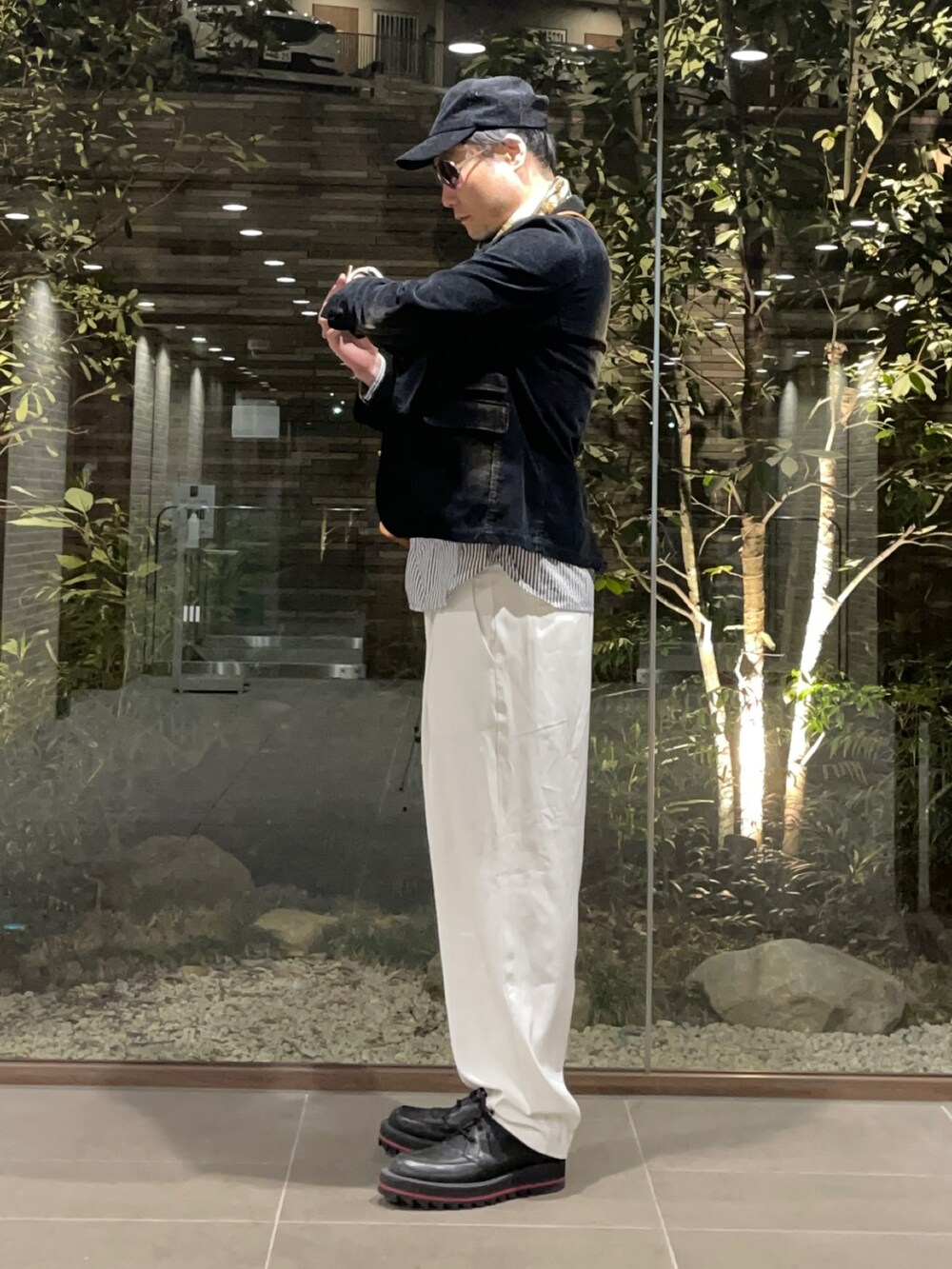 グレー系のシャツ/ブラウス、ブラック系のテーラードジャケット、ブラウン系のショルダーバッグを着用したメンズの春コーディネートの2枚目の写真