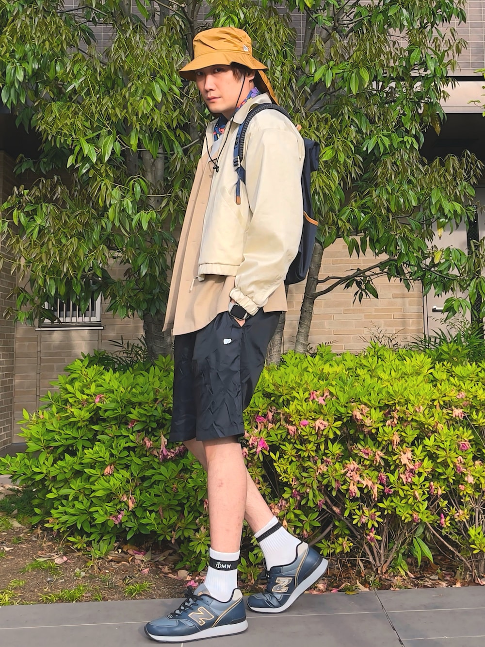 ブルー系のバックパック/リュック、ベージュ系のブルゾン、ベージュ系のシャツ/ブラウスを着用したメンズの春コーディネートの2枚目の写真