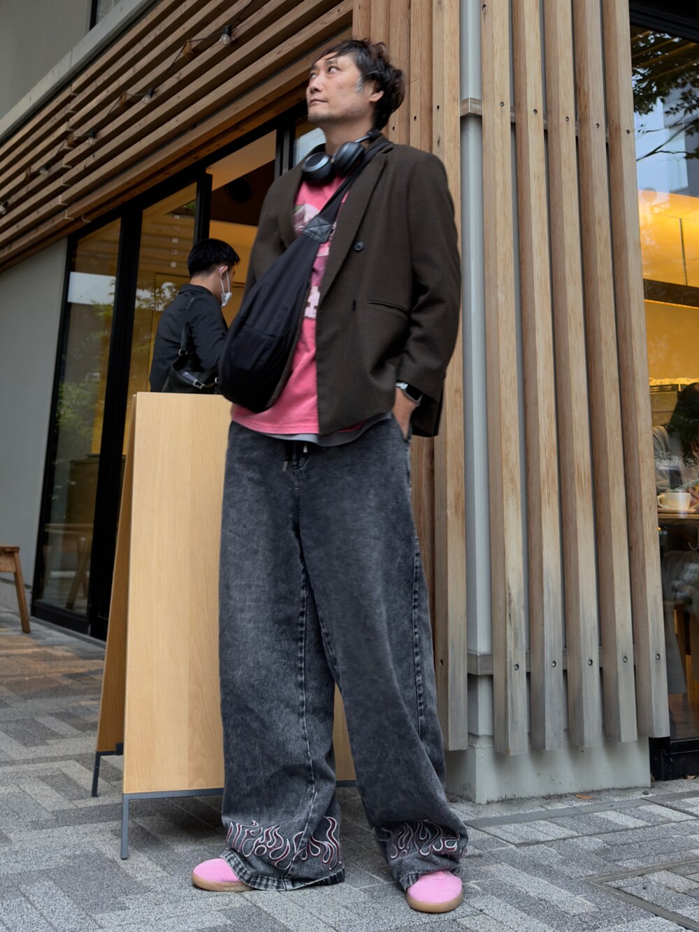 レッド系のTシャツ/カットソー、ブラック系のデニムパンツ、ブラック系のショルダーバッグを着用したメンズの秋コーディネートの2枚目の写真