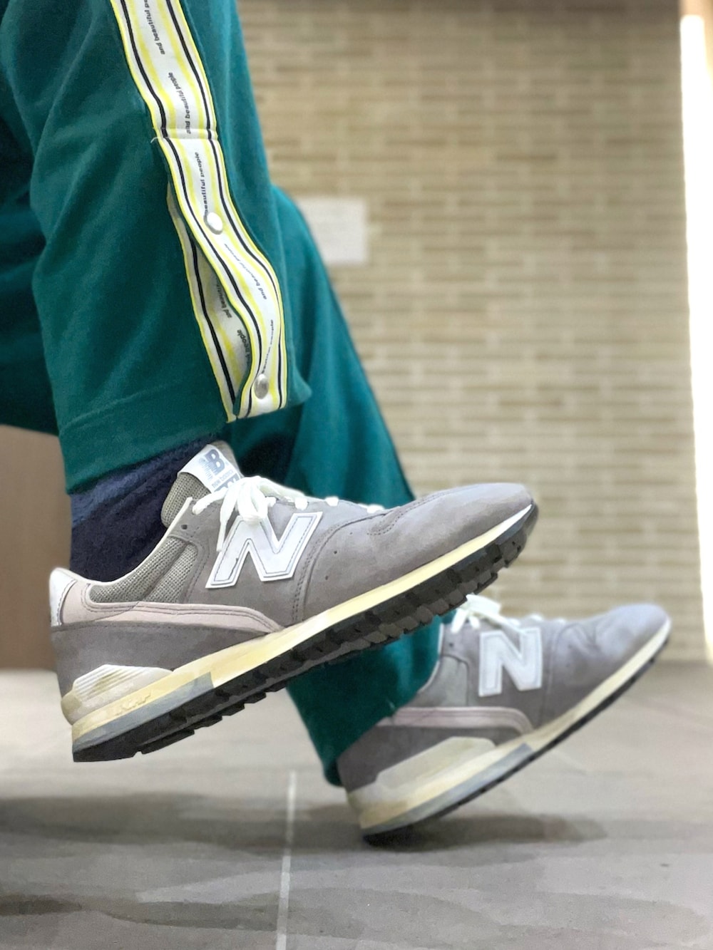 グリーン系のパーカー、ブラウン系のベスト、グリーン系のパンツを着用したメンズの春コーディネートの4枚目の写真