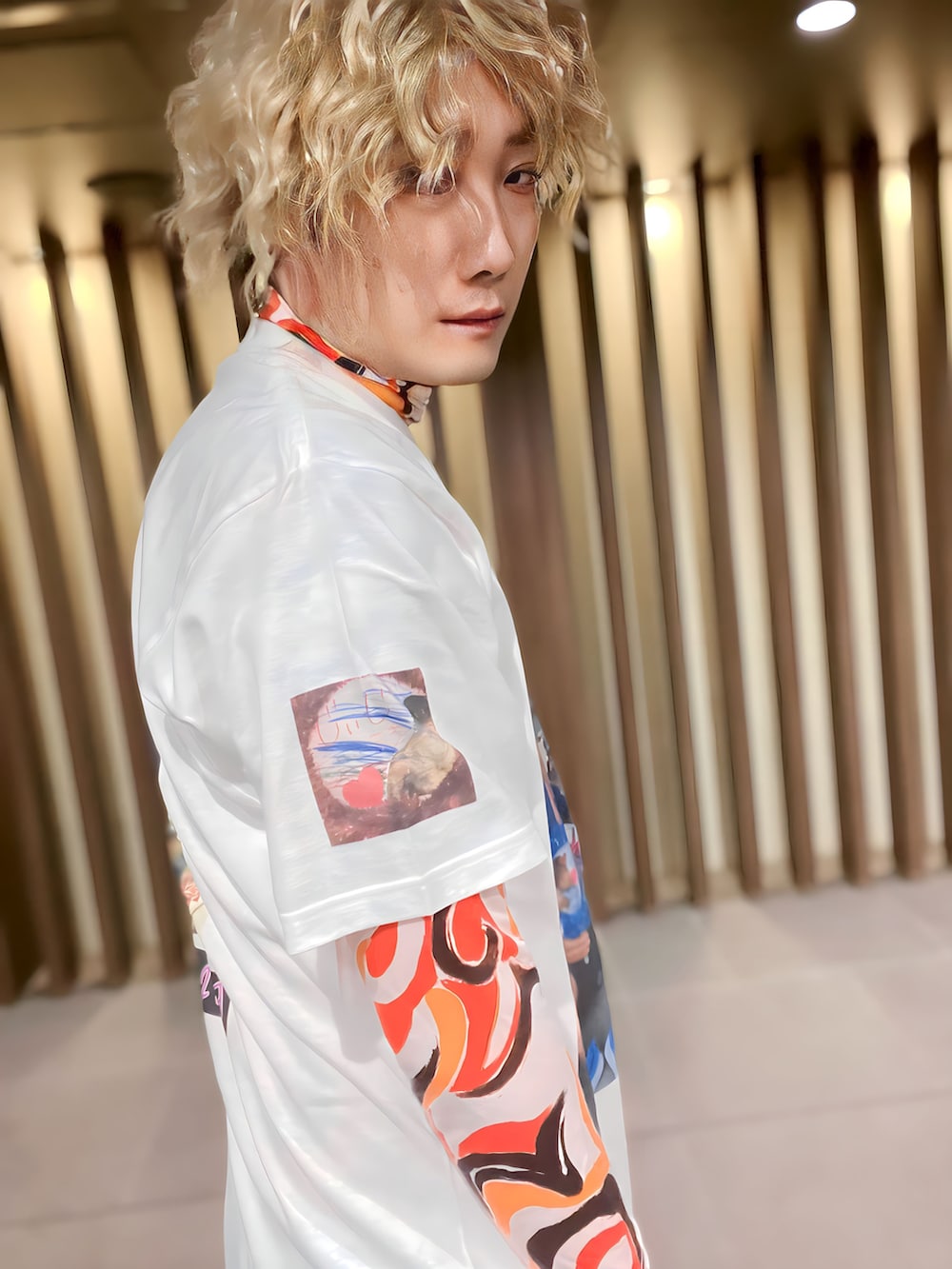 グレー系のテーラードジャケット、オレンジ系のトップス、ホワイト系のTシャツ/カットソーを着用したメンズの冬コーディネートの5枚目の写真