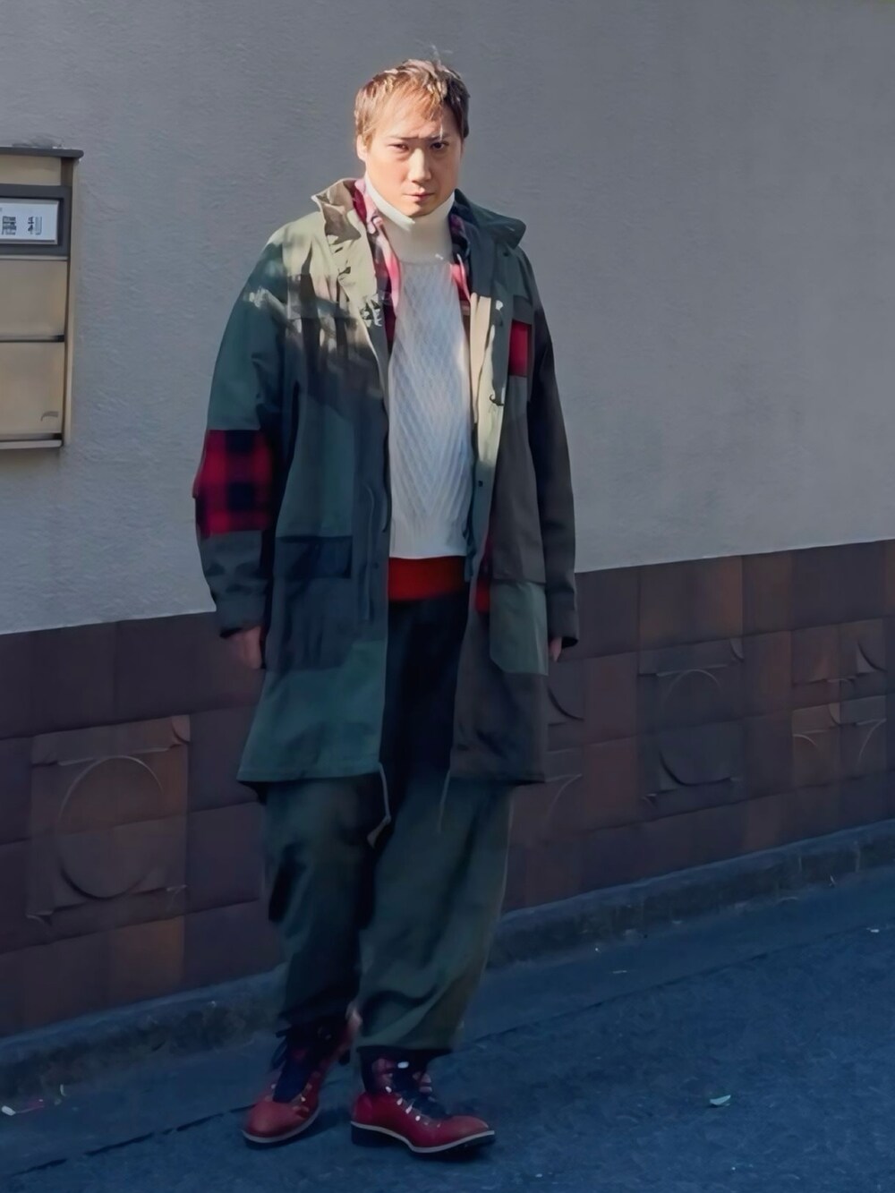 グリーン系のモッズコート、グリーン系のカーゴパンツ、レッド系のブーツを着用したメンズの冬コーディネートの5枚目の写真