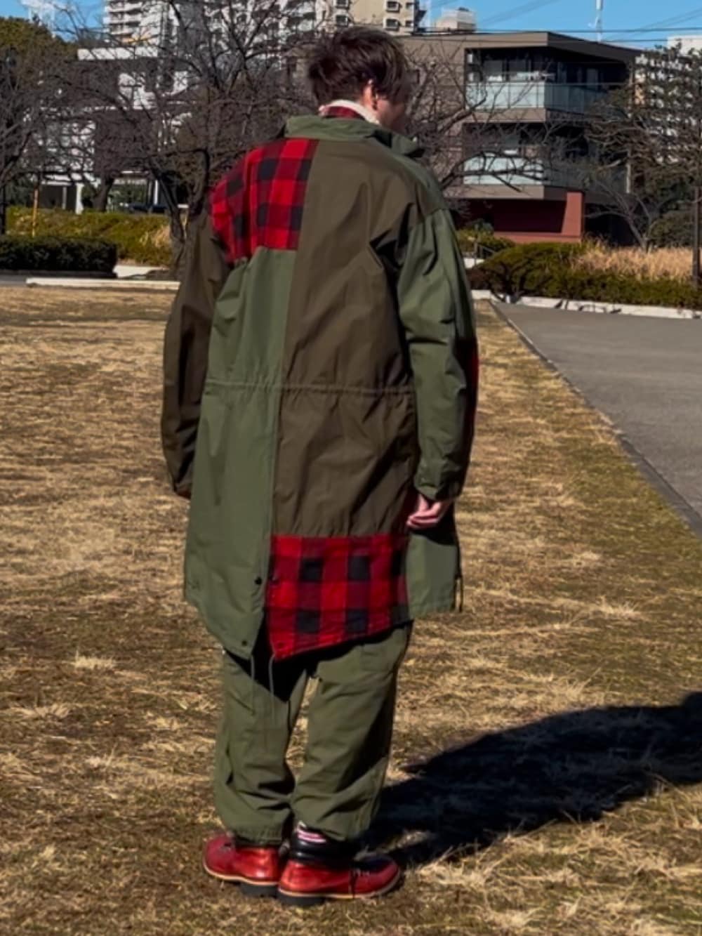 グリーン系のモッズコート、グリーン系のカーゴパンツ、レッド系のブーツを着用したメンズの冬コーディネートの4枚目の写真