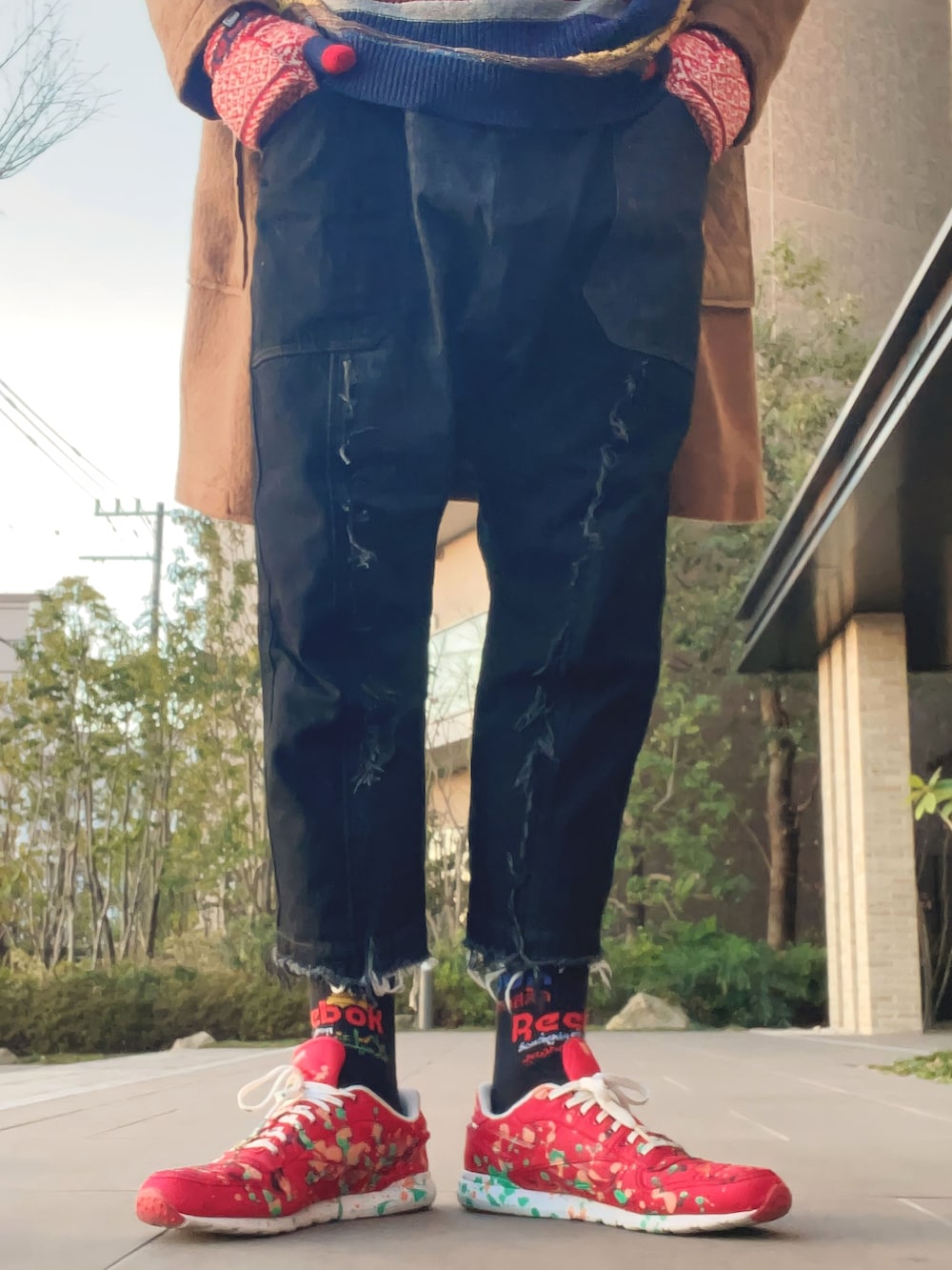 グリーン系のダッフルコート、その他のニット/セーター、ブラック系のデニムパンツを着用したメンズの春コーディネートの4枚目の写真