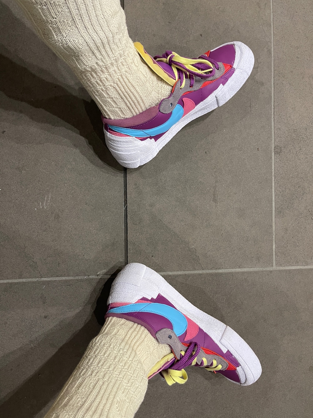 ブルー系のダウンベスト、グレー系のデニムスカート、パープル系のスニーカーを着用したメンズの秋コーディネートの4枚目の写真