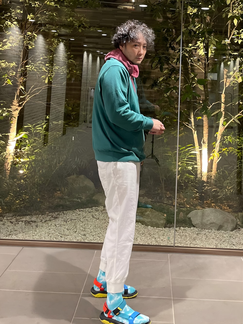 グリーン系のニット/セーター、ピンク系のパーカー、ホワイト系のその他パンツを着用したメンズの春コーディネートの2枚目の写真