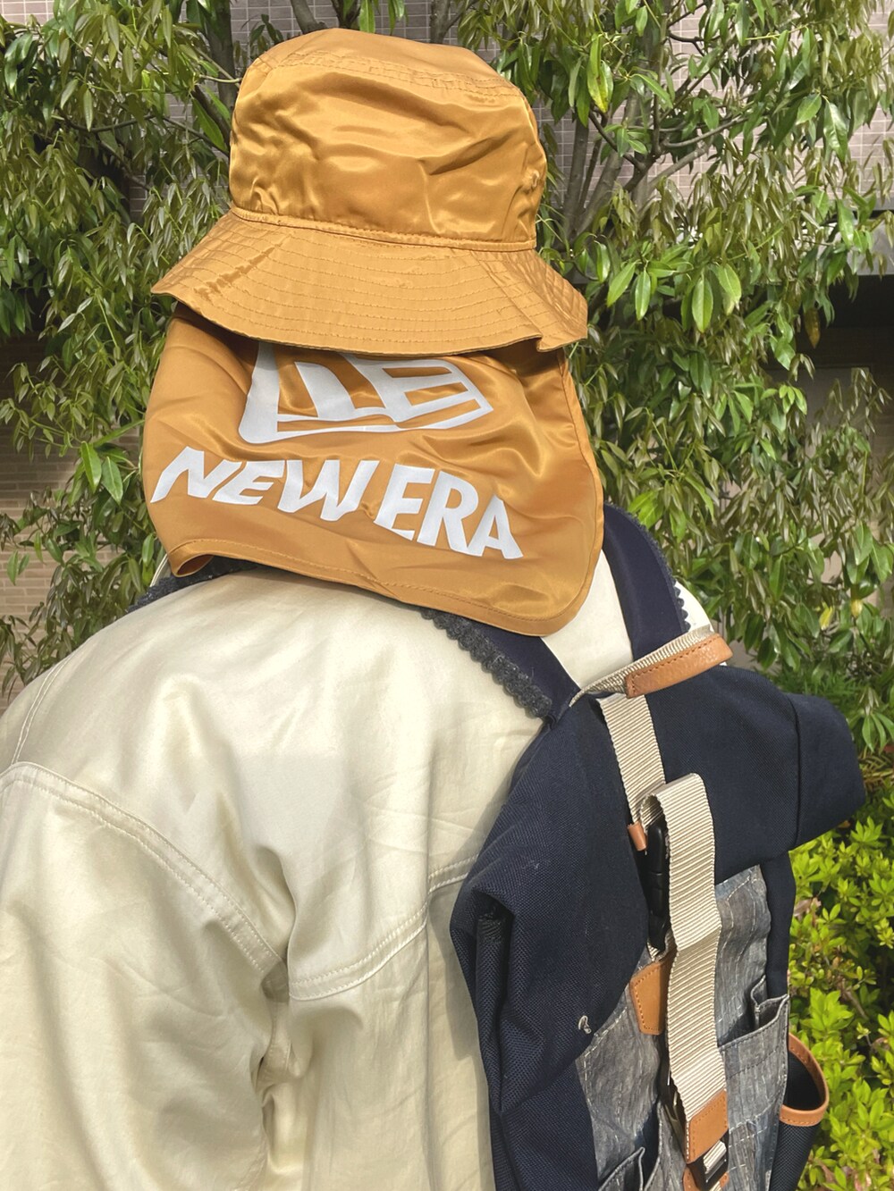 ブルー系のバックパック/リュック、ベージュ系のブルゾン、ベージュ系のシャツ/ブラウスを着用したメンズの春コーディネートの4枚目の写真