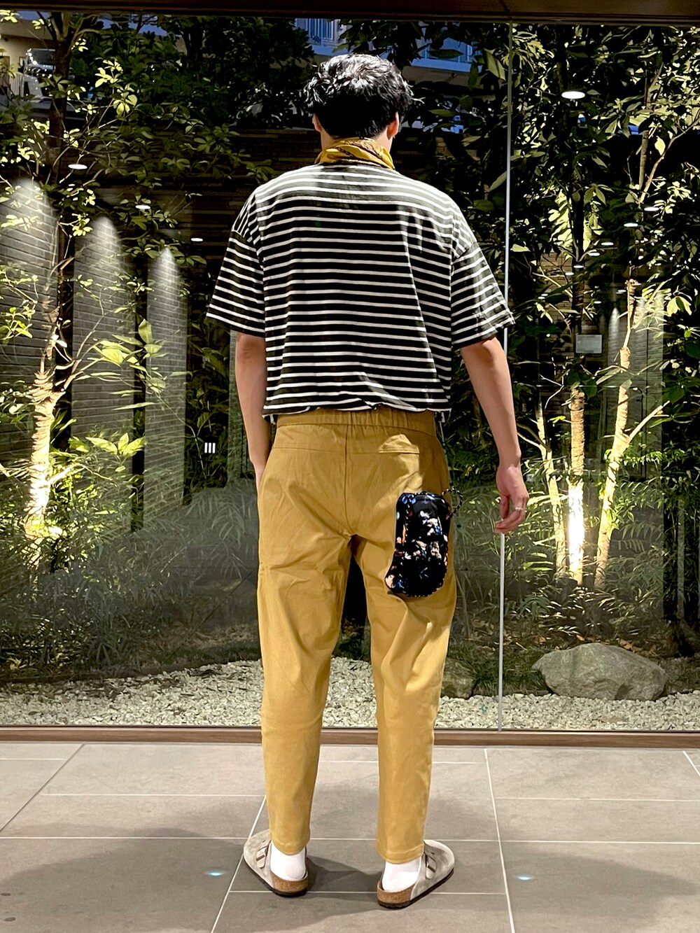 グリーン系のTシャツ/カットソー、ベージュ系のチノパンツ、ベージュ系のサンダルを着用したメンズの夏コーディネートの3枚目の写真