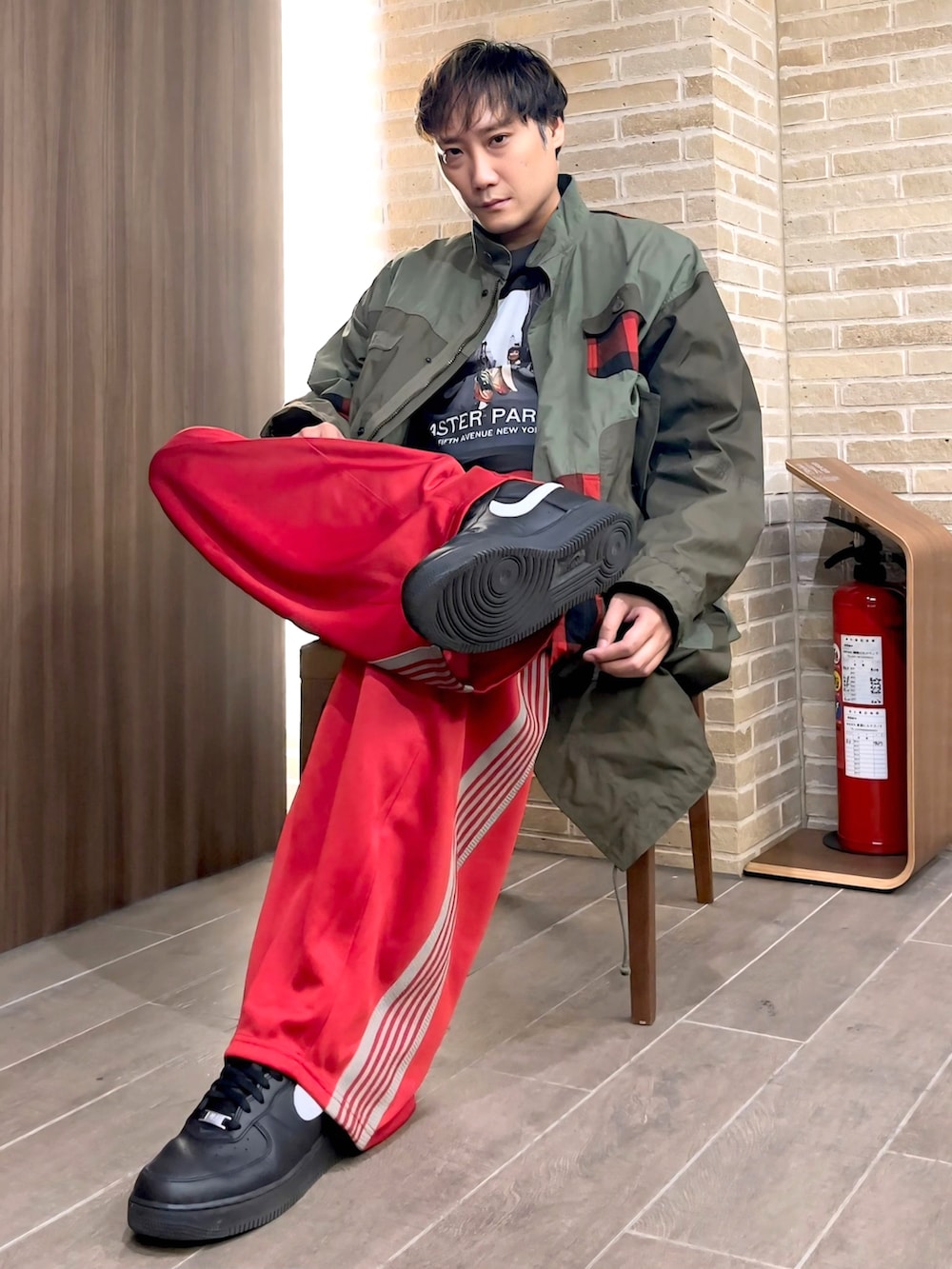 レッド系のその他パンツ、グリーン系のモッズコート、ブラック系のTシャツ/カットソーを着用したメンズの秋コーディネートの5枚目の写真