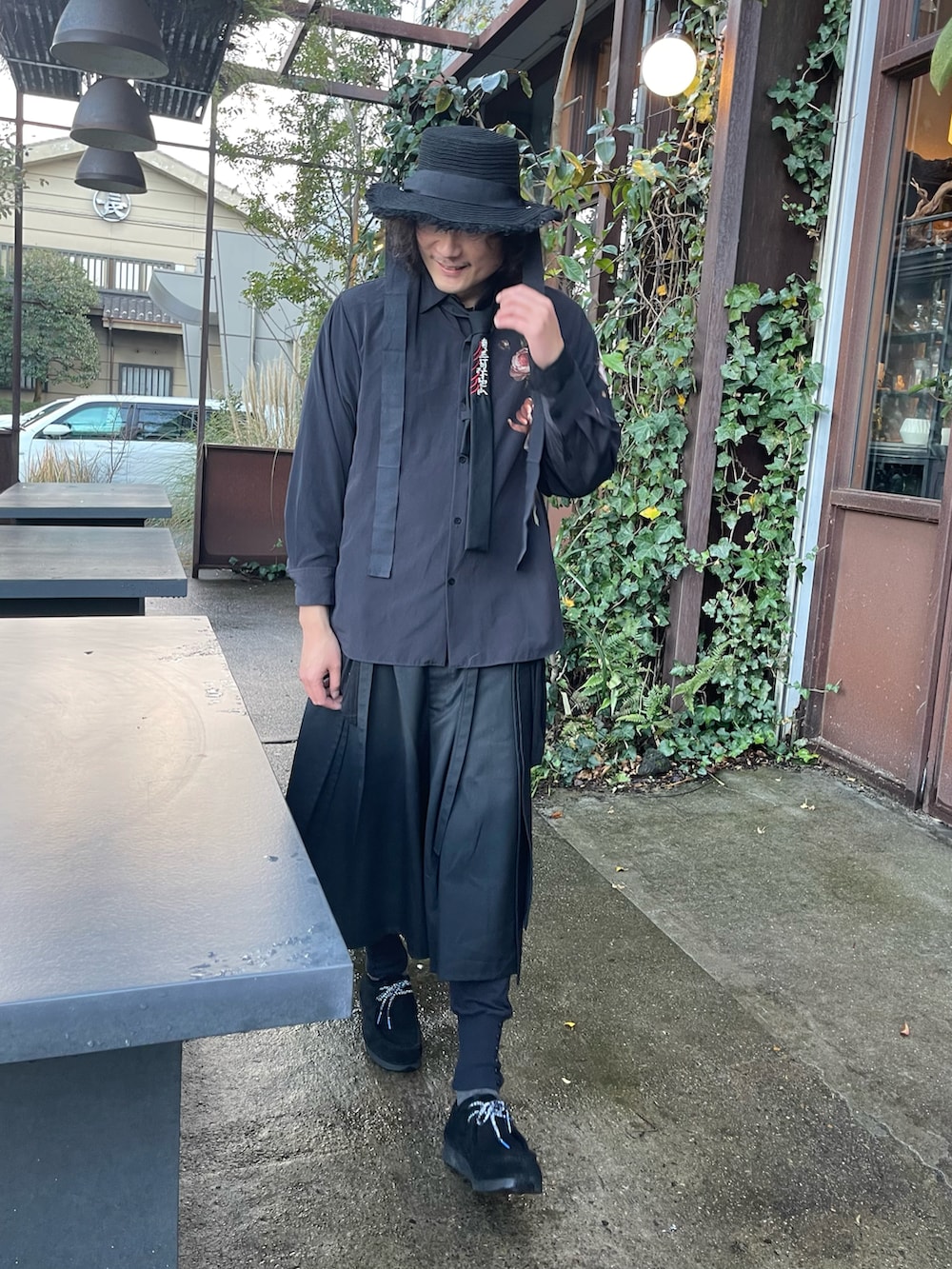 ブラック系のパンツ、ブラック系のモカシン/デッキシューズ、ブルー系のシューズアクセサリーを着用したメンズの冬コーディネートの4枚目の写真