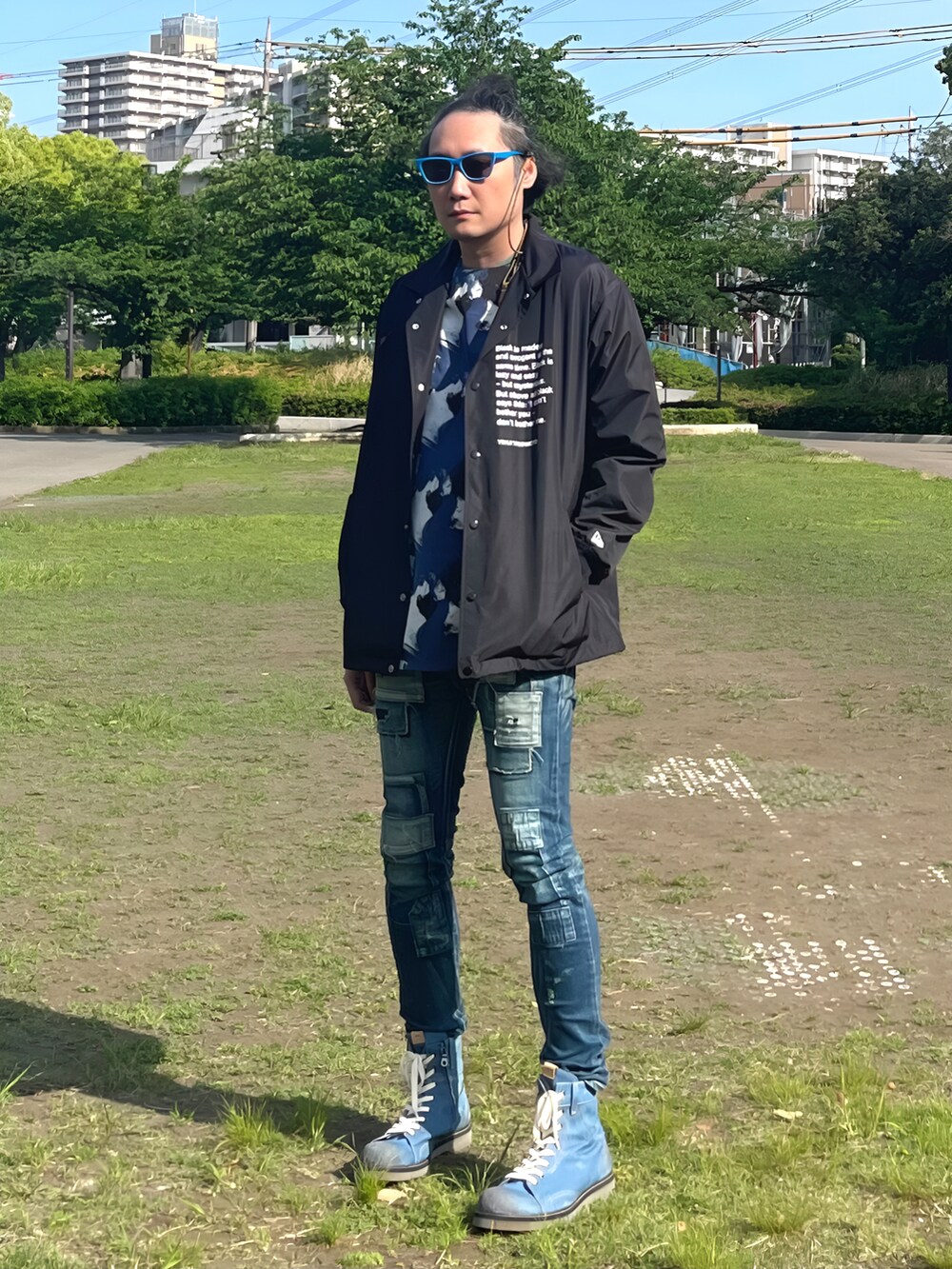 ブラック系のナイロンジャケット、ブルー系のTシャツ/カットソー、ブルー系のデニムパンツを着用したメンズの春コーディネートの2枚目の写真