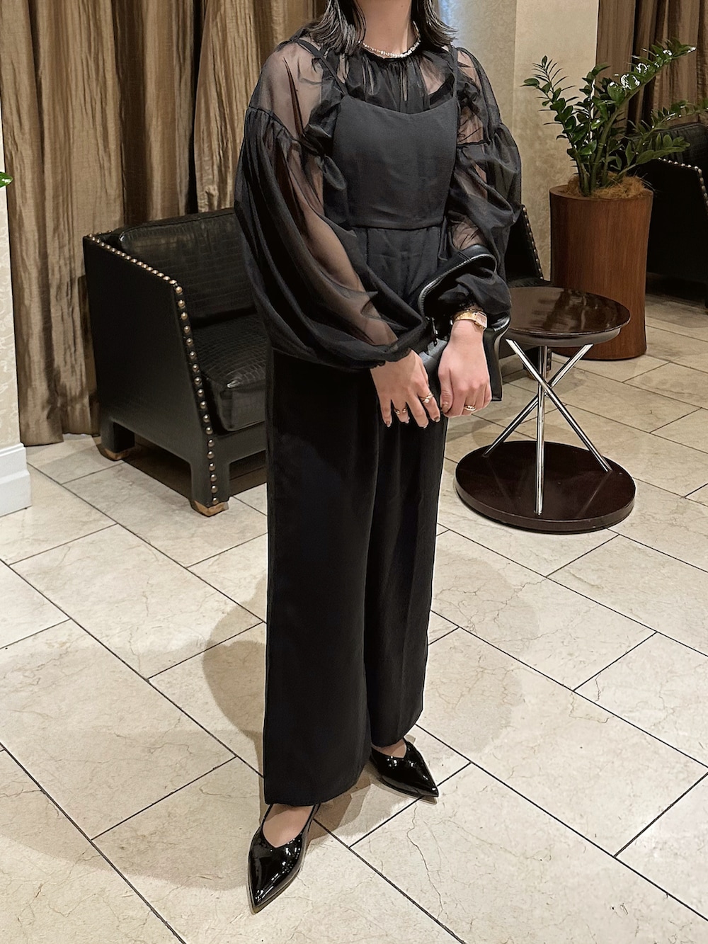 ブラック系のサロペット/オーバーオール、ブラック系のシャツ/ブラウス、ブラック系のハンドバッグを着用したレディースの春コーディネートの3枚目の写真