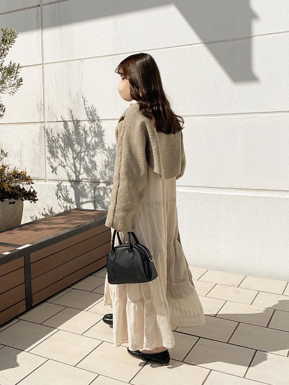 ベージュ系のワンピース、ブラック系のバッグ、ブラック系のシューズを着用したレディースの冬コーディネートの2枚目の写真