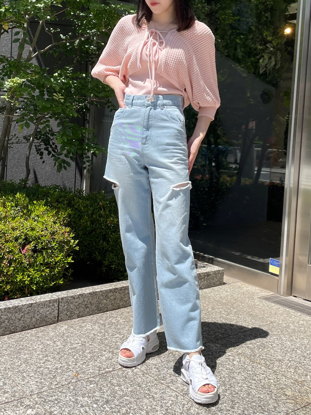 ピンク系のカーディガン/ボレロ、ブルー系のデニムパンツ、ホワイト系のサンダルを着用したレディースの春コーディネートの2枚目の写真