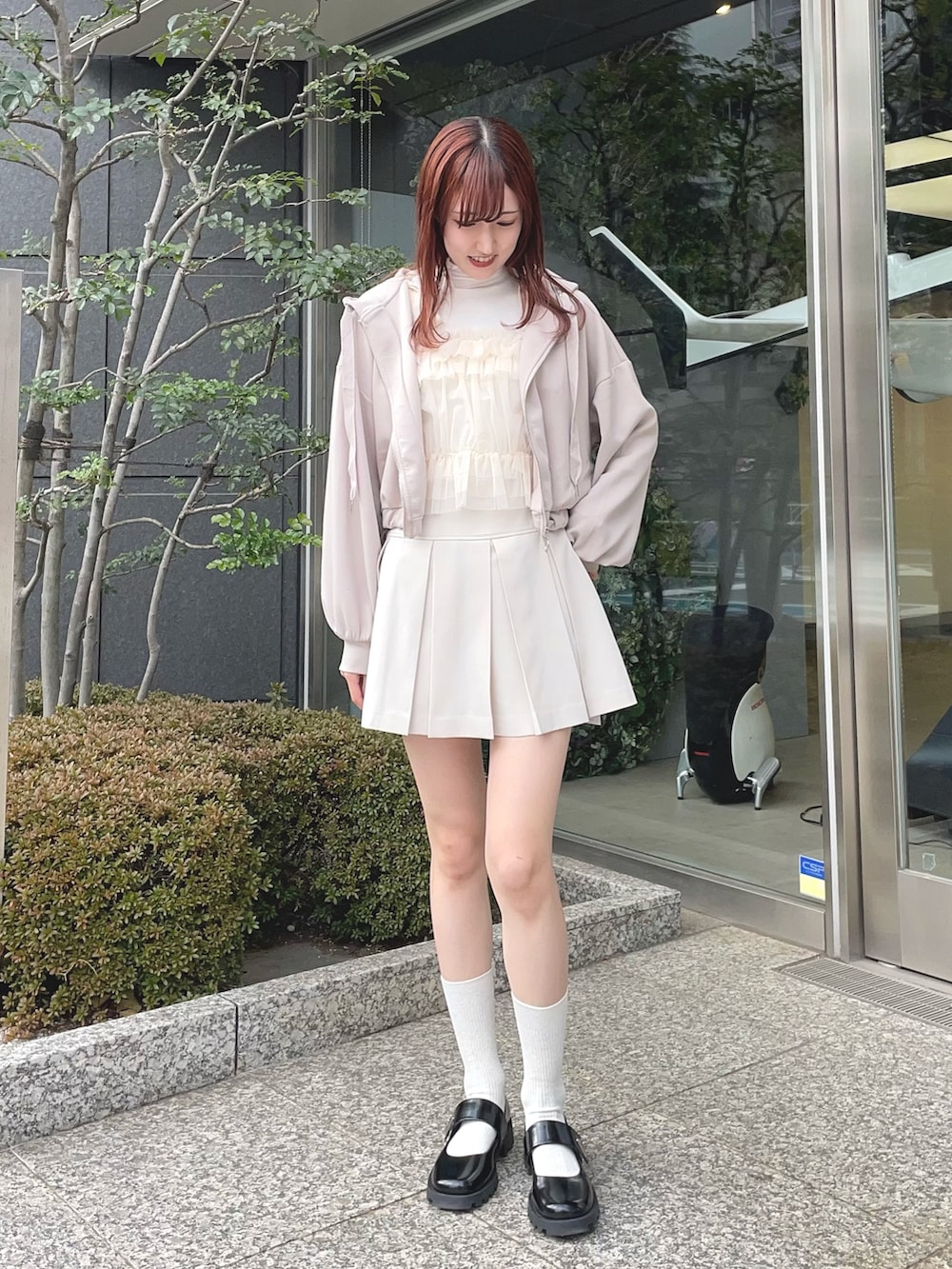 ホワイト系のTシャツ/カットソー、ベージュ系のスカート、ブラック系のパンプスを着用したレディースの冬コーディネートの2枚目の写真