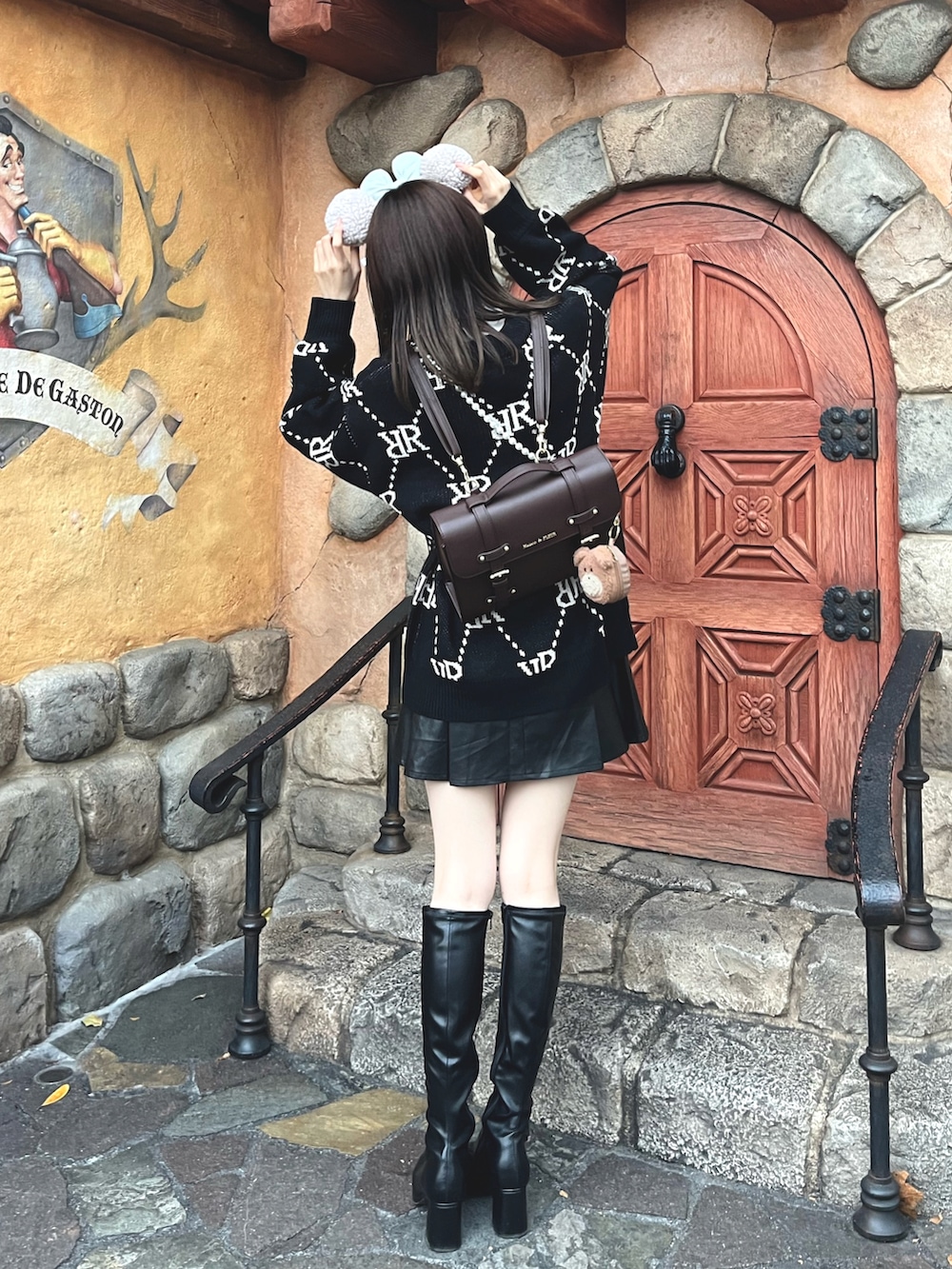 ブラック系のブーツ、ブラック系のスカート、ブラック系のカーディガン/ボレロを着用したレディースの冬コーディネートの2枚目の写真