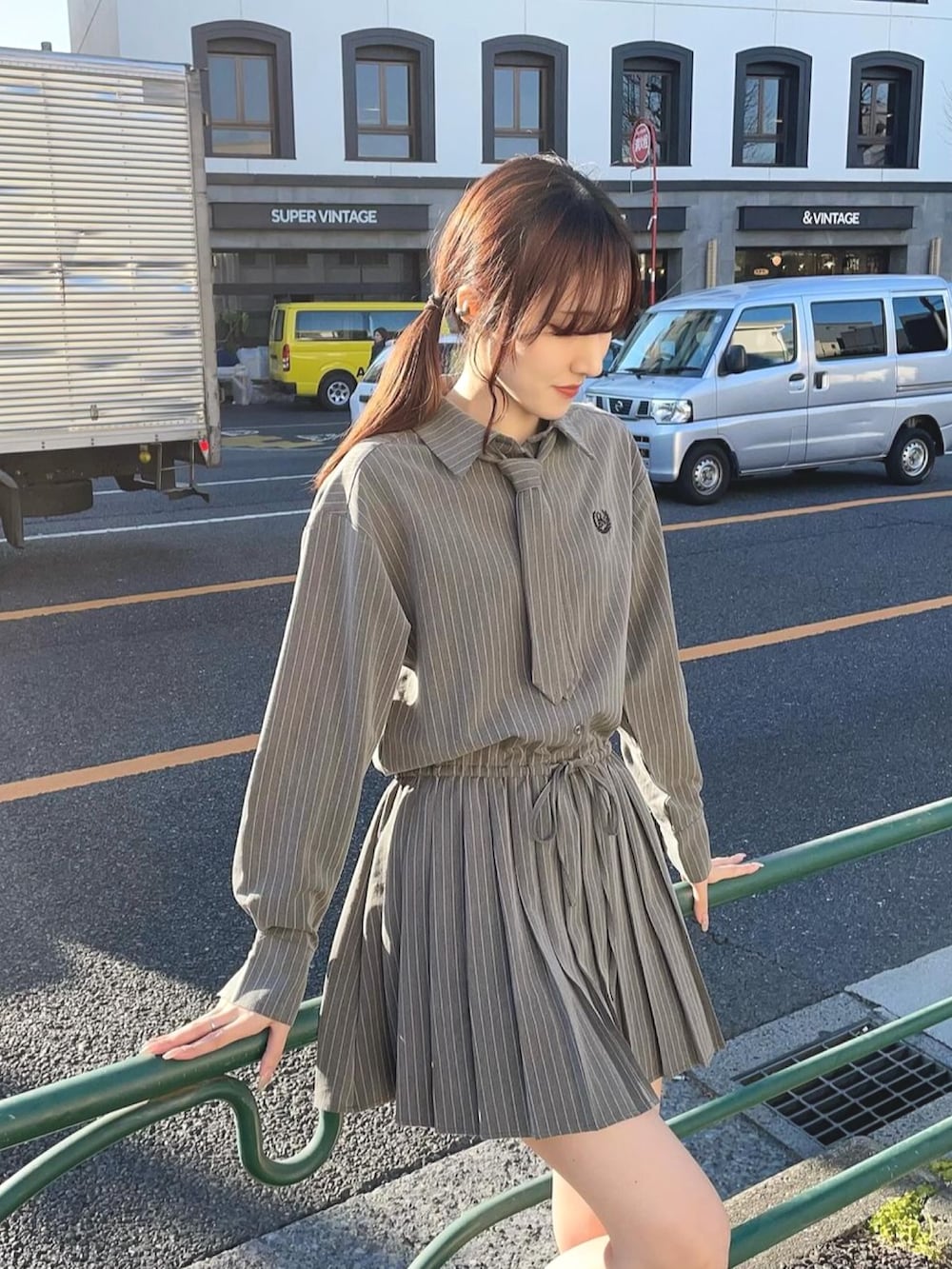 グレー系のワンピース、ブラック系のブーツを着用したレディースの冬コーディネートの2枚目の写真