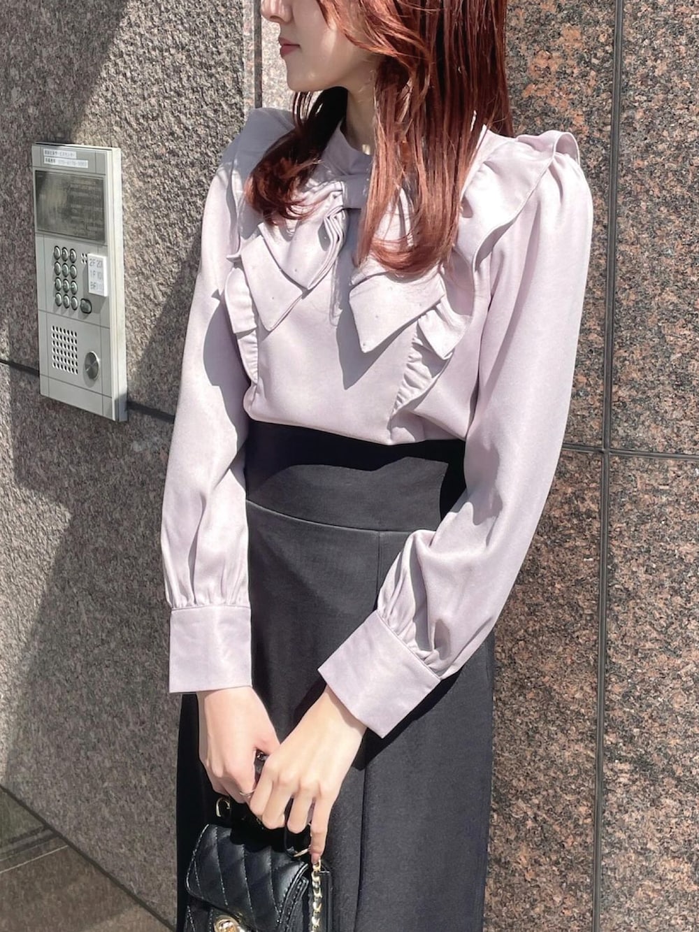 ブラック系のバッグ、ピンク系のシャツ/ブラウス、ブラック系のパンプスを着用したレディースの春コーディネートの2枚目の写真