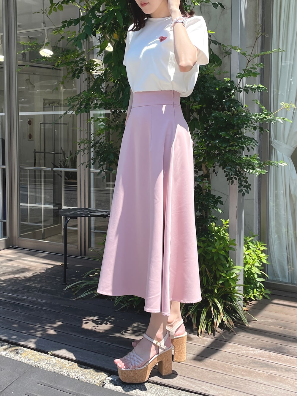 ベージュ系のTシャツ/カットソー、ピンク系のスカート、ベージュ系のサンダルを着用したレディースの春コーディネートの2枚目の写真