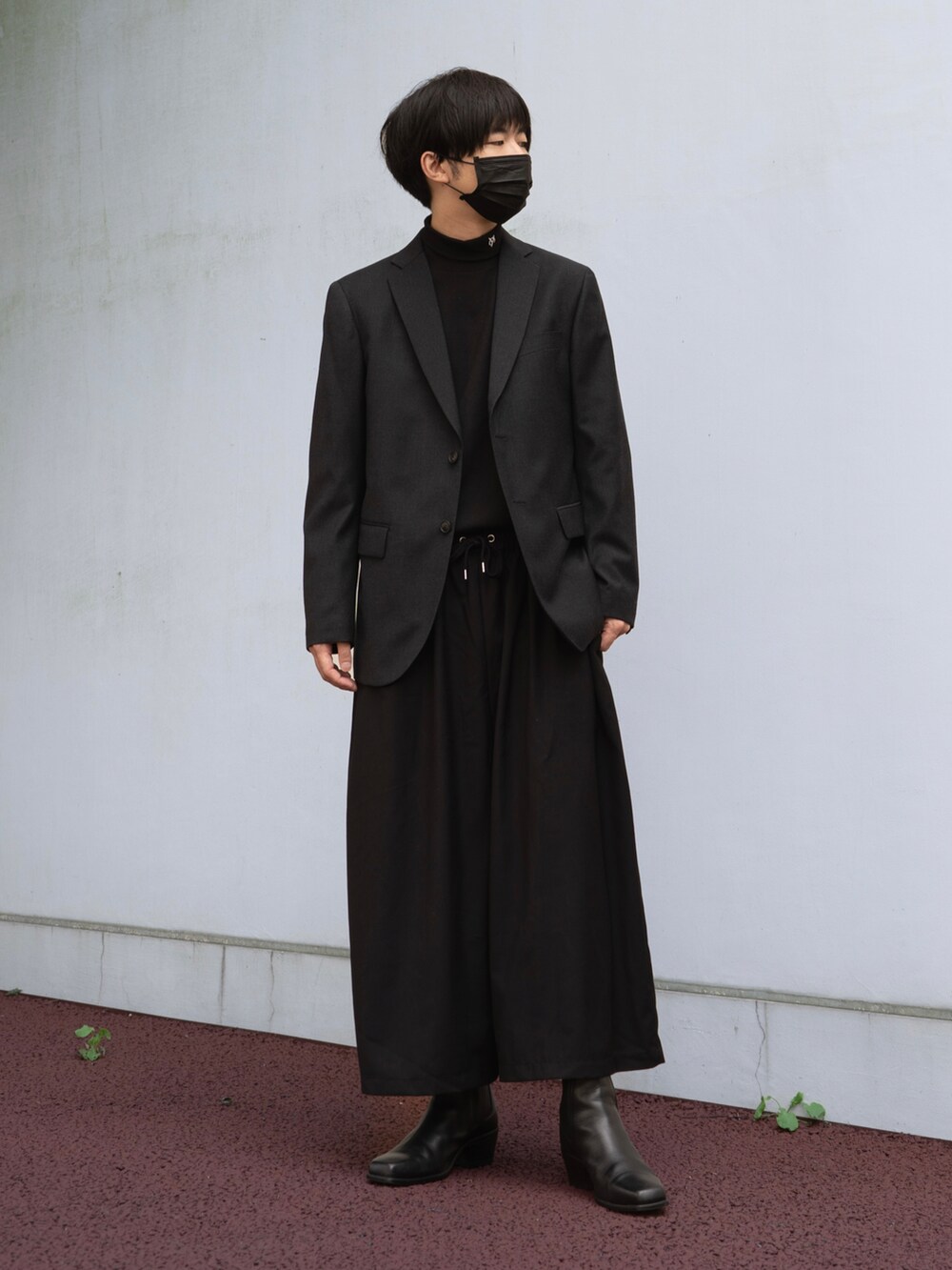 ブラック系のテーラードジャケット、ブラック系のその他パンツ、ブラック系のブーツを着用したメンズの秋コーディネートの3枚目の写真