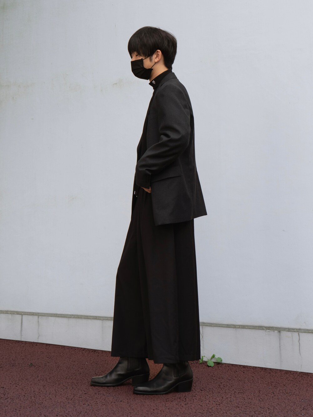 ブラック系のテーラードジャケット、ブラック系のその他パンツ、ブラック系のブーツを着用したメンズの秋コーディネートの2枚目の写真