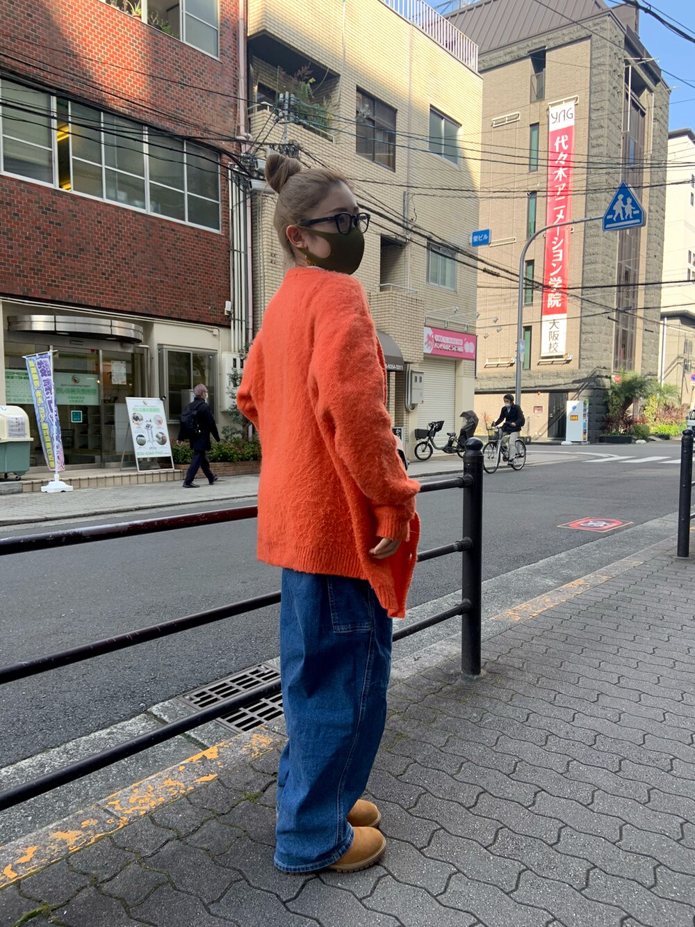 ブルー系のデニムパンツ、ホワイト系のその他トップス、オレンジ系のカーディガン/ボレロを着用したレディースの春コーディネートの2枚目の写真