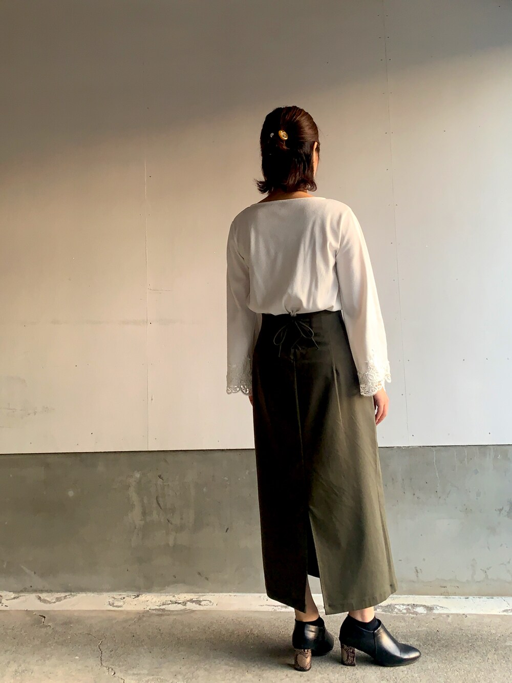 グリーン系のスカート、ホワイト系のTシャツ/カットソーを着用したレディースの春コーディネートの2枚目の写真