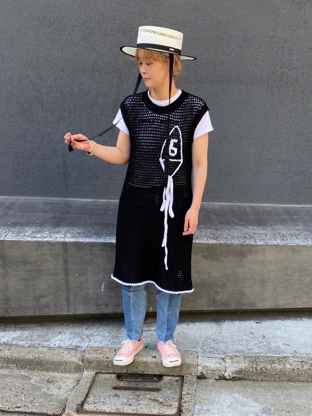 ブラック系のワンピース、ピンク系のスニーカー、ホワイト系のハットを着用したレディースの夏コーディネートの3枚目の写真