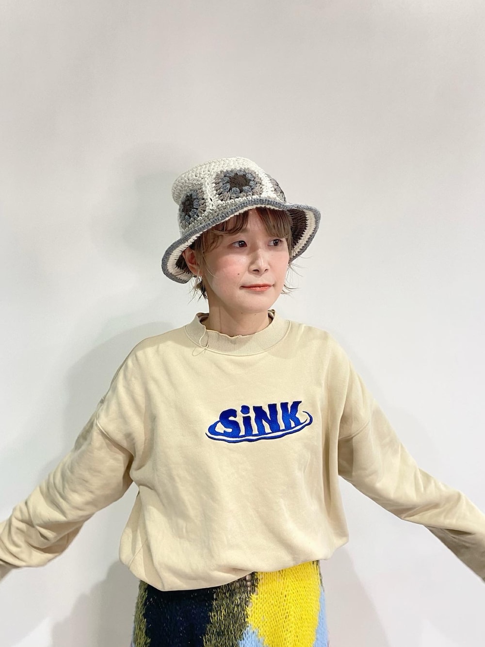 ベージュ系のスウェット、イエロー系のスカート、シルバー系のスニーカーを着用したレディースの冬コーディネートの3枚目の写真