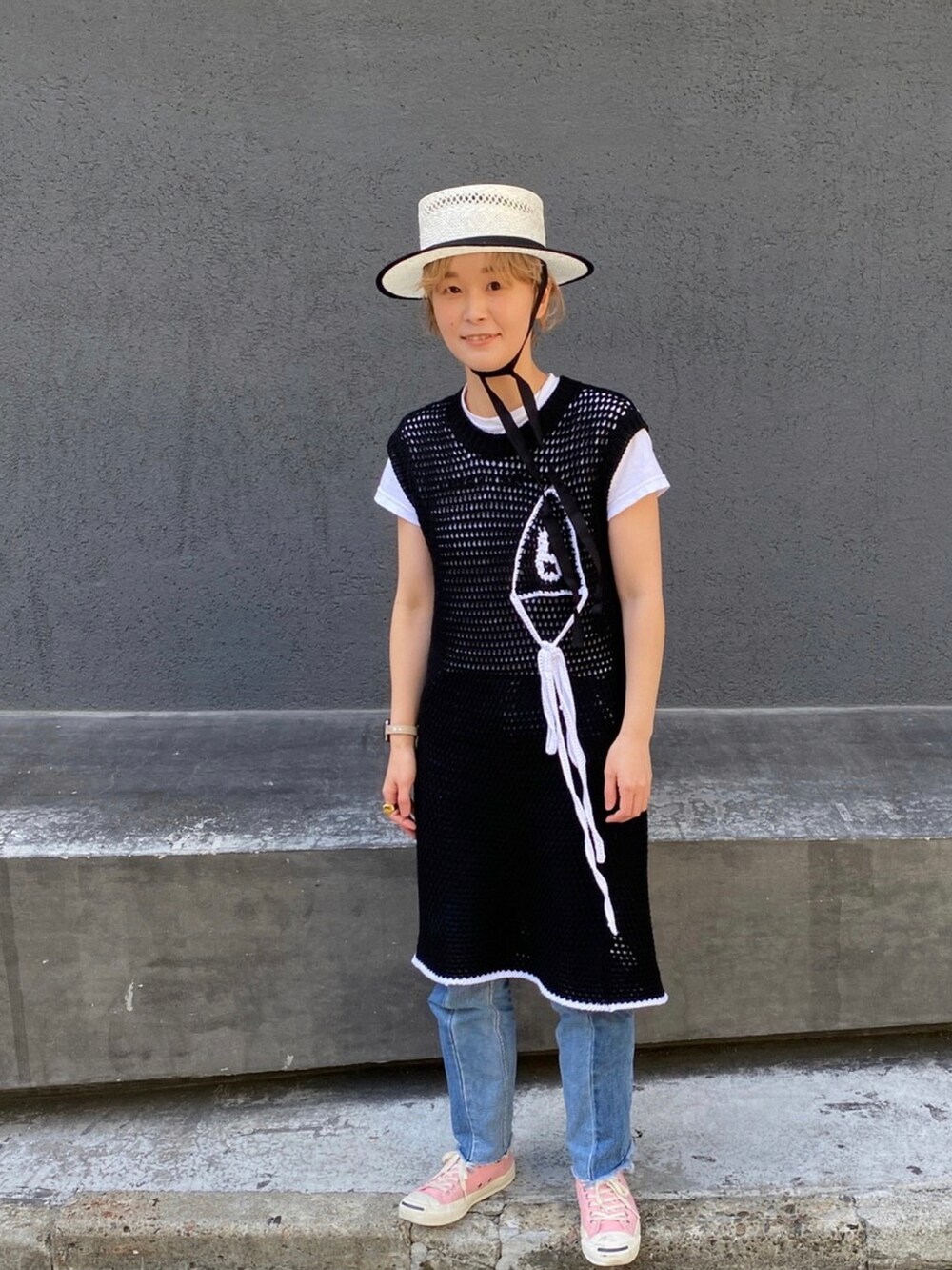 ブラック系のワンピース、ピンク系のスニーカー、ホワイト系のハットを着用したレディースの夏コーディネートの4枚目の写真