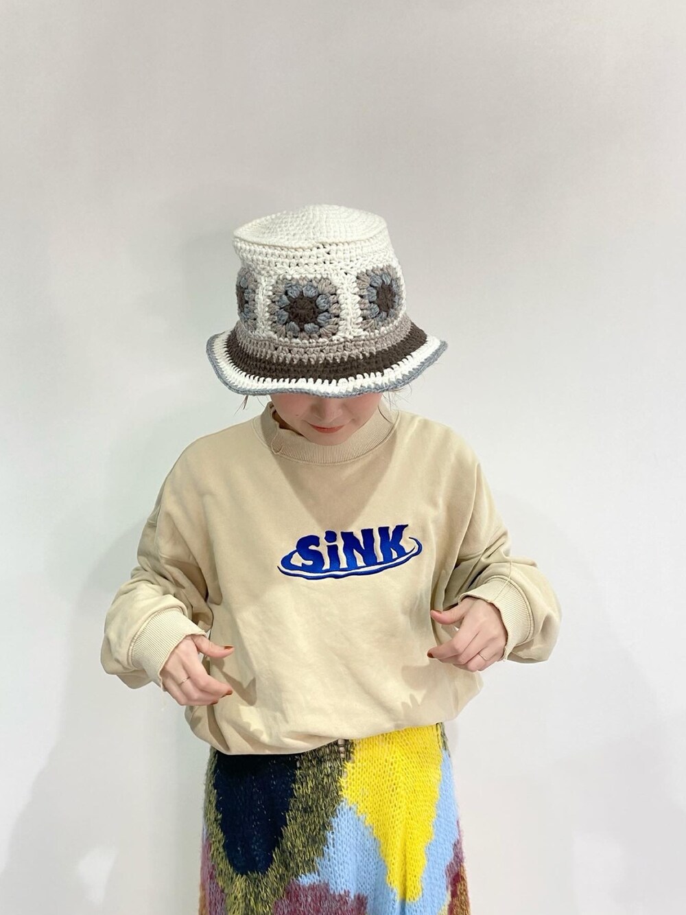 ベージュ系のスウェット、イエロー系のスカート、シルバー系のスニーカーを着用したレディースの冬コーディネートの4枚目の写真