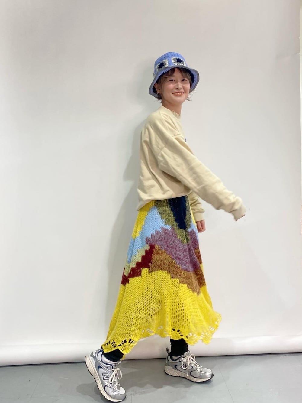 ベージュ系のスウェット、イエロー系のスカート、シルバー系のスニーカーを着用したレディースの冬コーディネートの2枚目の写真