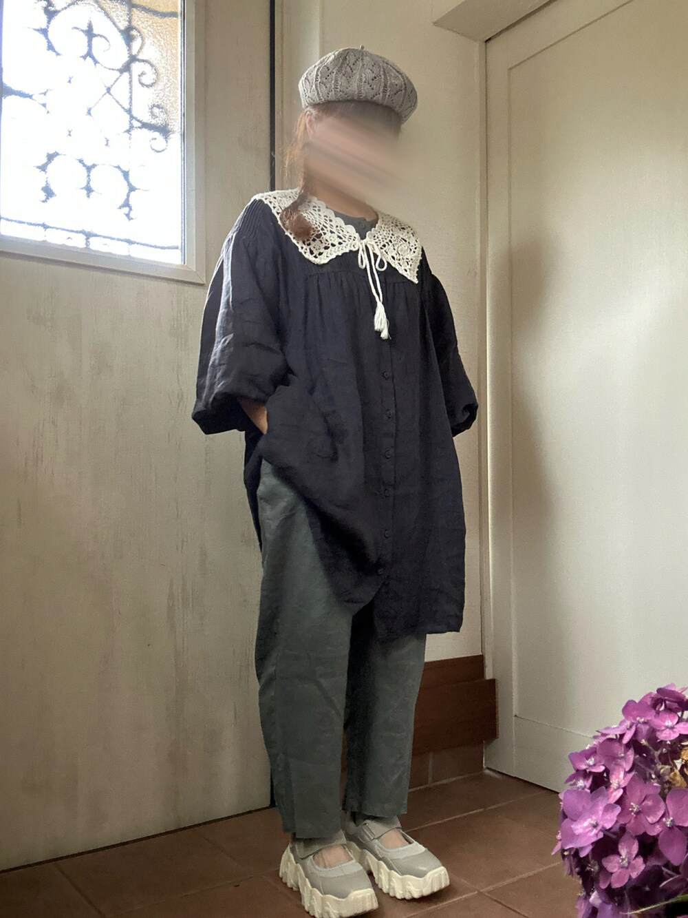 ブルー系のチュニック、グレー系のパンツ、グレー系のドレスシューズを着用したレディースの夏コーディネートの2枚目の写真