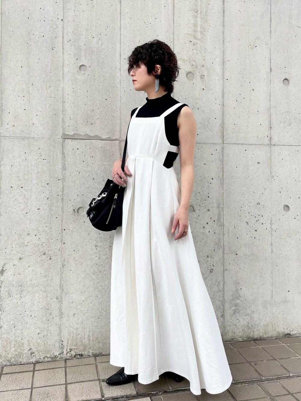 ホワイト系のワンピース、ブラック系のショルダーバッグ、ブラック系のニット/セーターを着用したレディースの春コーディネートの2枚目の写真