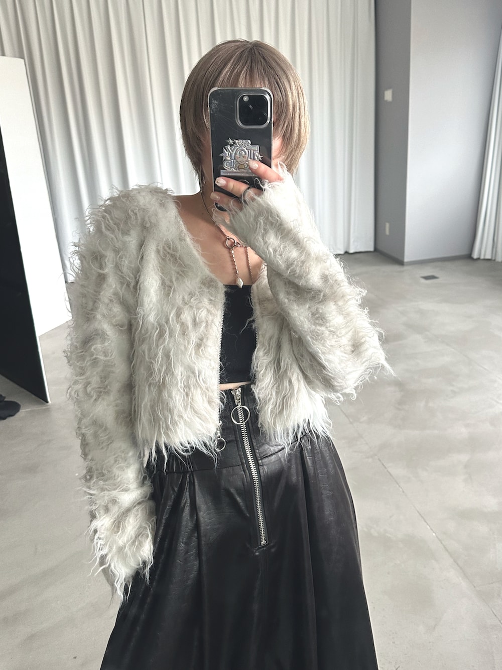 ホワイト系のニット/セーター、ブラック系のスカート、シルバー系のブーツを着用したレディースの秋コーディネートの3枚目の写真