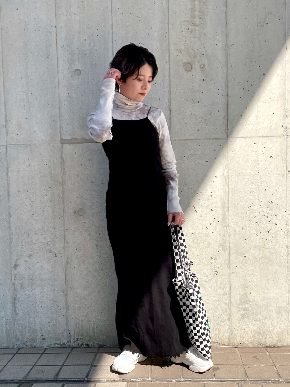 ブラック系のトートバッグ、ブラック系のワンピース、ベージュ系のTシャツ/カットソーを着用したレディースの春コーディネートの2枚目の写真