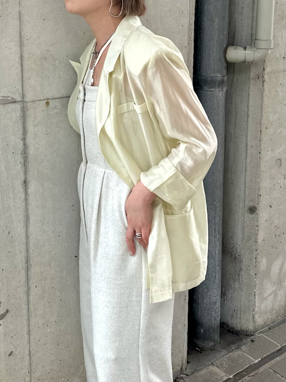 ホワイト系のサロペット/オーバーオール、イエロー系のテーラードジャケット、ホワイト系のキャミソールを着用したレディースの夏コーディネートの4枚目の写真