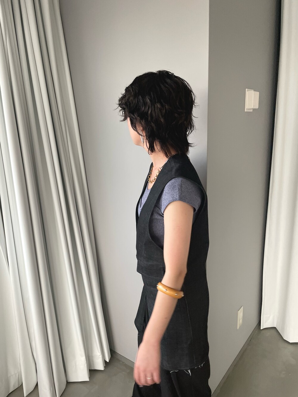 ブラック系のベスト、ブラック系のスラックス、ブルー系のニット/セーターを着用したレディースの夏コーディネートの4枚目の写真