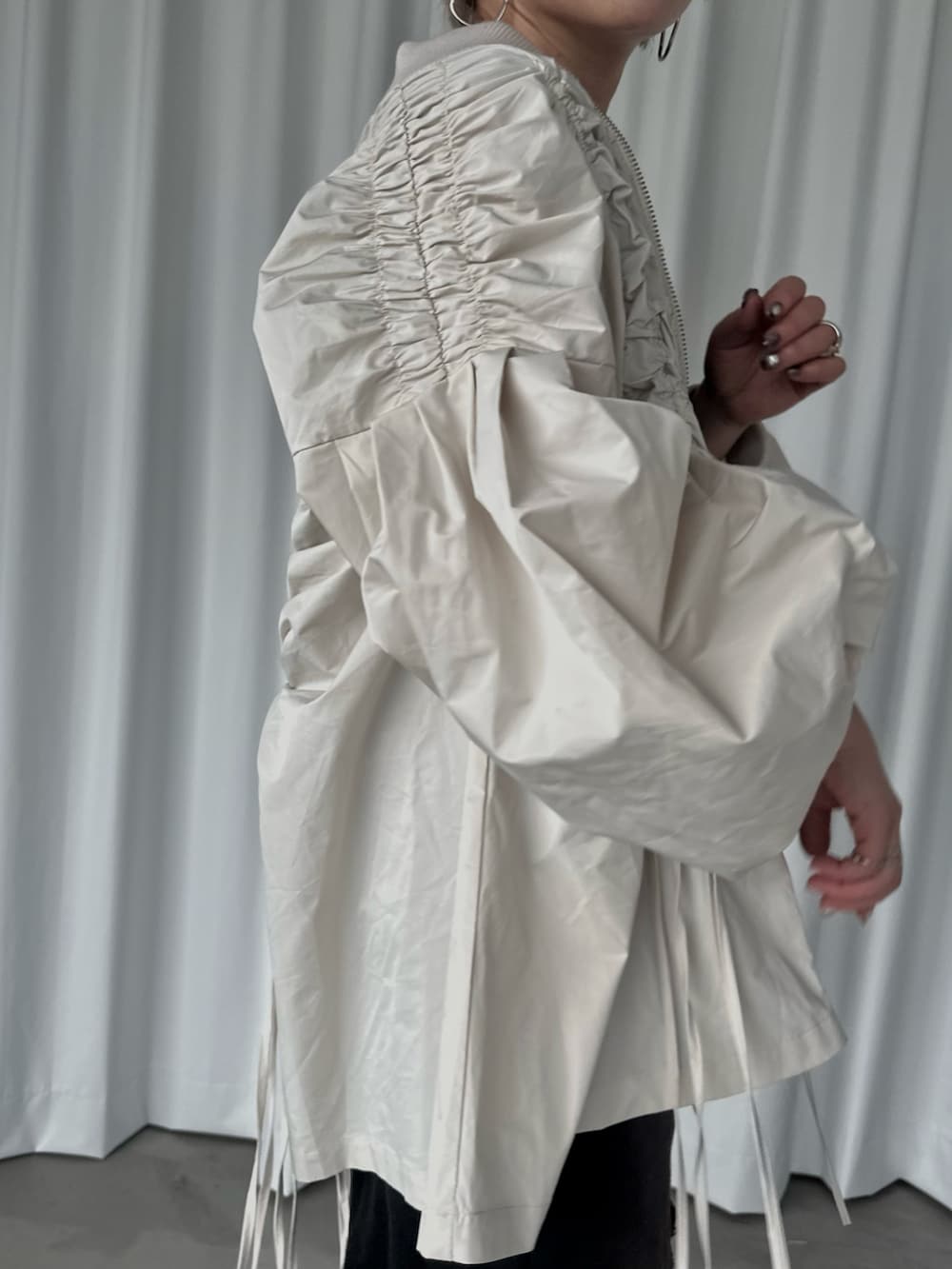 ブラック系のスウェットパンツ、ブラック系のタンクトップ、ホワイト系のブルゾンを着用したレディースの秋コーディネートの3枚目の写真