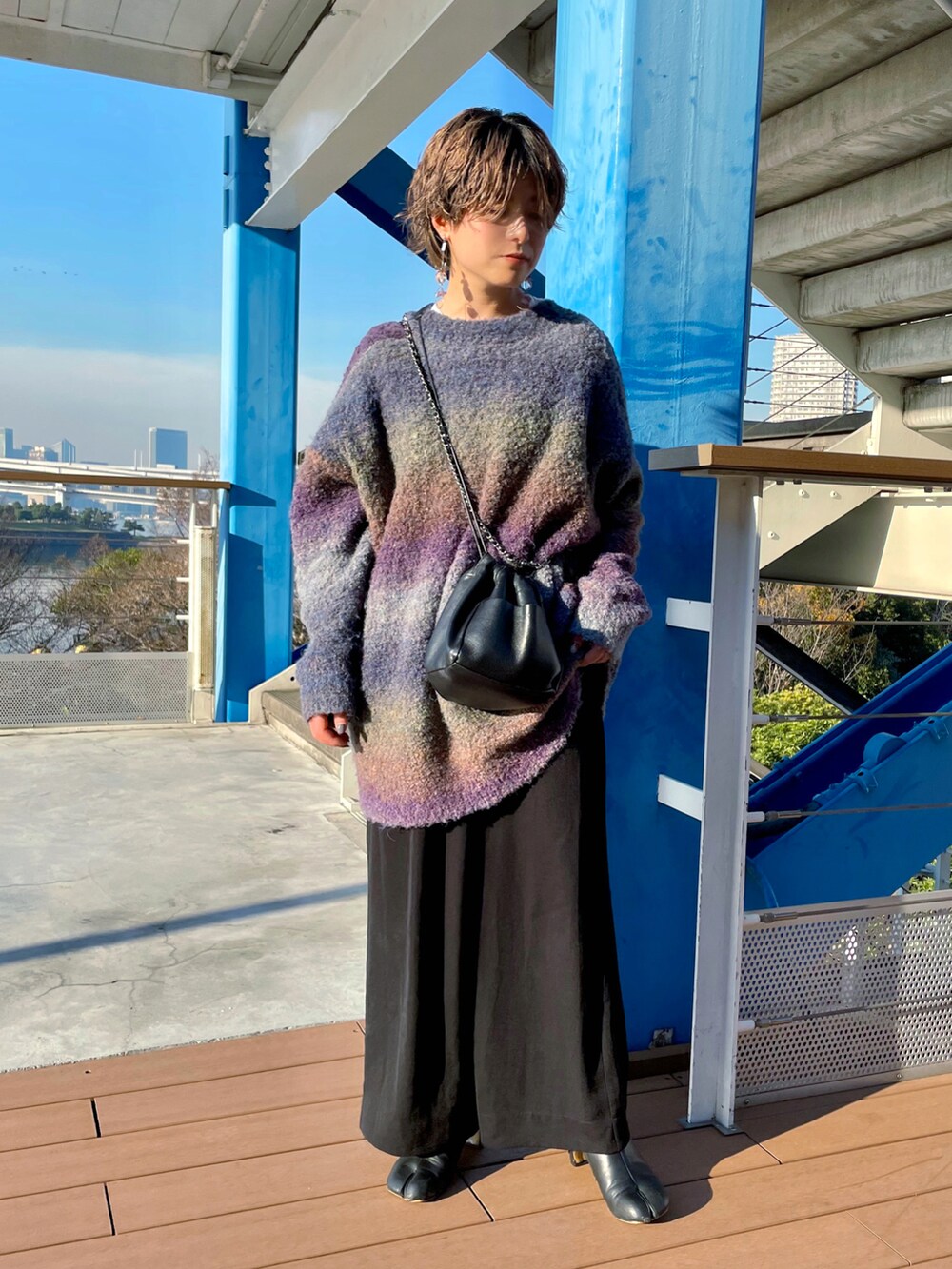 ホワイト系のダウンジャケット/コート、パープル系のニット/セーター、ブラック系のパンツを着用したレディースの冬コーディネートの2枚目の写真